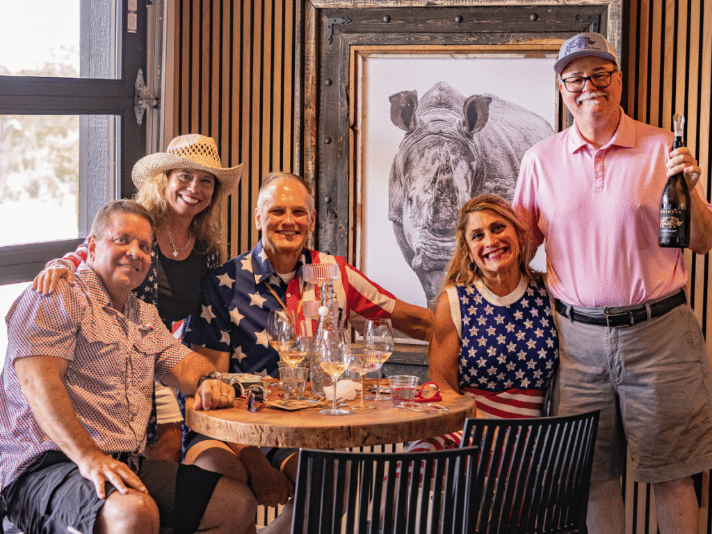 A party seated in Club Rhino beneath the framed rhino portrait